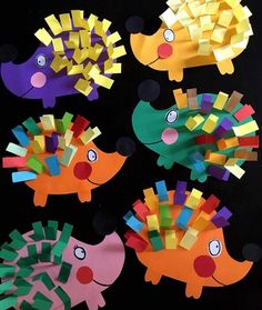 some paper crafts that are shaped like fish and hedgehogs on a black background