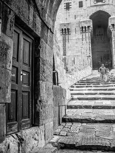 black and white photograph of stairs leading to an old building with stone steps in the foreground