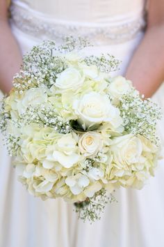 a bridal holding a bouquet of white flowers