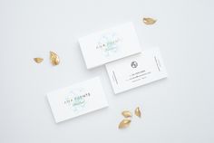 three business cards with gold leaves on them