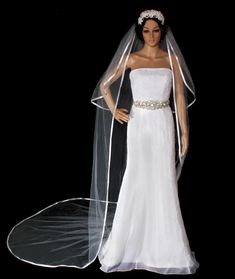 a mannequin dressed in a wedding dress and veil, with a black background