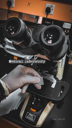 a person in white gloves is looking through a pair of bins on a microscope