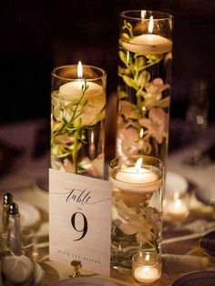 two tall vases filled with flowers and candles