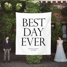 a man and woman standing next to a white banner that says best day ever on it