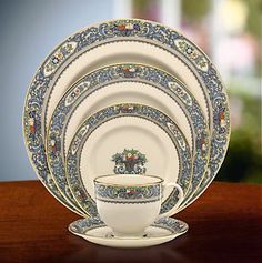 an ornately decorated dinner set with blue and gold trimmings on the rim