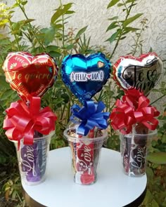 three vases filled with foil hearts and wrapped in red, white, and blue ribbons