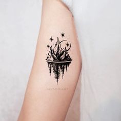 a tattoo with mountains and stars on it