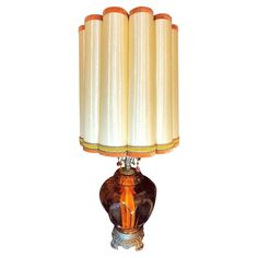 a table lamp with four candles on it's base and an orange glass shade