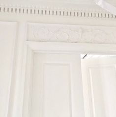 an open door with white paint and decorative molding on the trim around it's edges