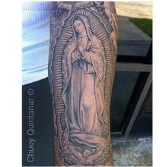 a person with a tattoo on their arm and the image of mary in grey ink