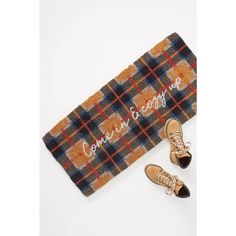 two pairs of shoes sitting on top of a plaid scarf