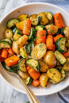 a white bowl filled with roasted vegetables on top of a table