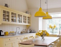 a kitchen filled with yellow and white furniture