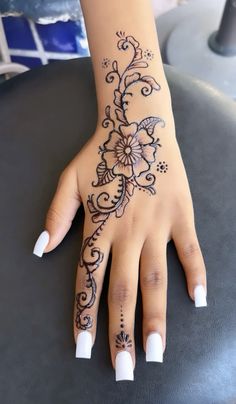 a woman's hand with henna tattoos on it