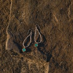 A turquoise pendant dangles from a textured silver-casted vine. 2.5" long. Elegant Patina Earrings, Green Sterling Silver Hammered Jewelry, Green Hammered Sterling Silver Jewelry, Turquoise Sterling Silver Long Drop Earrings, Turquoise Long Drop Sterling Silver Earrings, Oxidized Sterling Silver Long Drop Jewelry, Hand Forged Turquoise Sterling Silver Earrings, Metal Drop Earrings With Patina, Handmade Long Drop Metal Jewelry