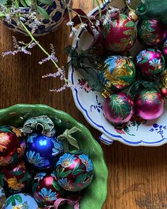 two bowls filled with ornaments on top of a wooden table