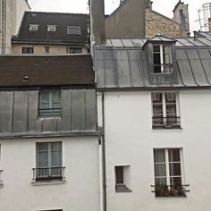 an old building with some windows and a clock on the top of it's roof