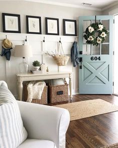 a living room filled with furniture and pictures hanging on the wall next to a blue door