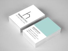 two white business cards with blue accents on the front and back, sitting side by side