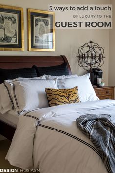 there is a bed with white sheets and pillows on it, next to two framed pictures