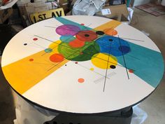 a round table painted with different colors and shapes