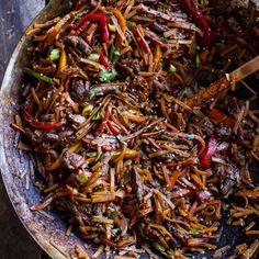 a skillet filled with stir fried noodles and vegetables