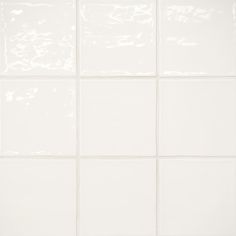 a white tile wall with several square tiles