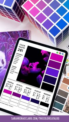 a panda bear sitting on top of a table next to some color swatches and other items