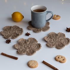 some cookies and cinnamon sticks are next to a cup of tea