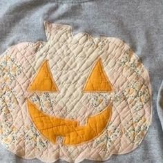 a gray shirt with an orange pumpkin on it