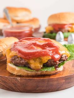 a cheeseburger with ketchup and lettuce on a wooden board