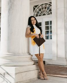 a woman standing next to a white column