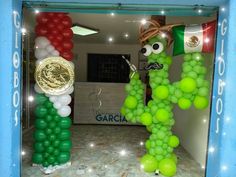 an arch made out of balloons with a mexican flag on it and a gold coin