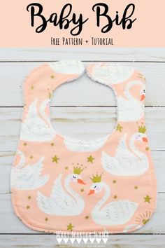 a pink bib with white swans on it and the words baby bibs written in black