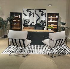 two chairs sitting on top of a rug in front of a desk