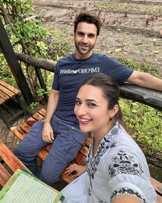 a man and woman sitting next to each other on a bench