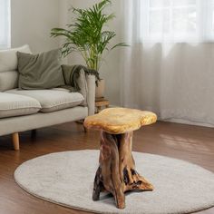 a wooden table sitting on top of a rug in a living room next to a couch