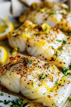 some fish on a plate with lemons and herbs