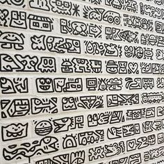 some writing on a white brick wall with black and white letters written in different languages