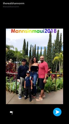 the family is posing for a photo in front of some trees and bushes with their name on it