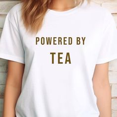 ----- The Design ----- For those who can't or won't start their day without a nice cup of tea! Are you blissfully aware that the day only truly starts after your first sip of tea? Then this tea tee was made for you! Our "Powered by Tea" unisex t-shirt has an apt, relatable message perfect for any tea lover, caffeine addict or proper brew aficionado!  Why You'll Love It: ☕️ Everyday Style: Make every tea & coffee run stylish and fun with this "Powered by Tea" t-shirt! Whether you're treating your Tea Humor, Tea And Biscuits, Caffeine Addict, Cuppa Tea, Tea Shirt, Fun Cup, Cup Of Tea, Tea Lover, Everyday Style