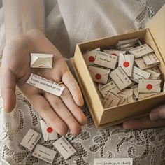 a person holding a box filled with small pieces of paper