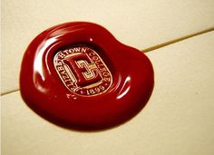 a close up of a red button on a tile floor with the letter d in it