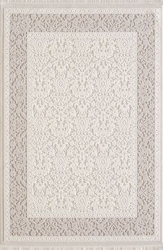 a white rug with an intricate design on the top and bottom, along with a beige border