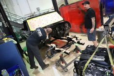 two men working on an engine in a garage