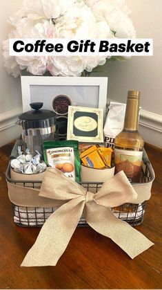 a basket filled with wine, cookies and other items next to a bouquet of flowers