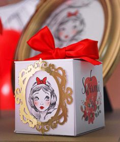 a box with a bow on it sitting next to a mirror and other items in the background