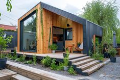 a small house made out of wood and metal with stairs leading up to the front door