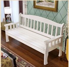 a white bench sitting on top of a hard wood floor