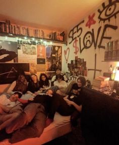 a group of people laying on top of a bed in a room filled with books